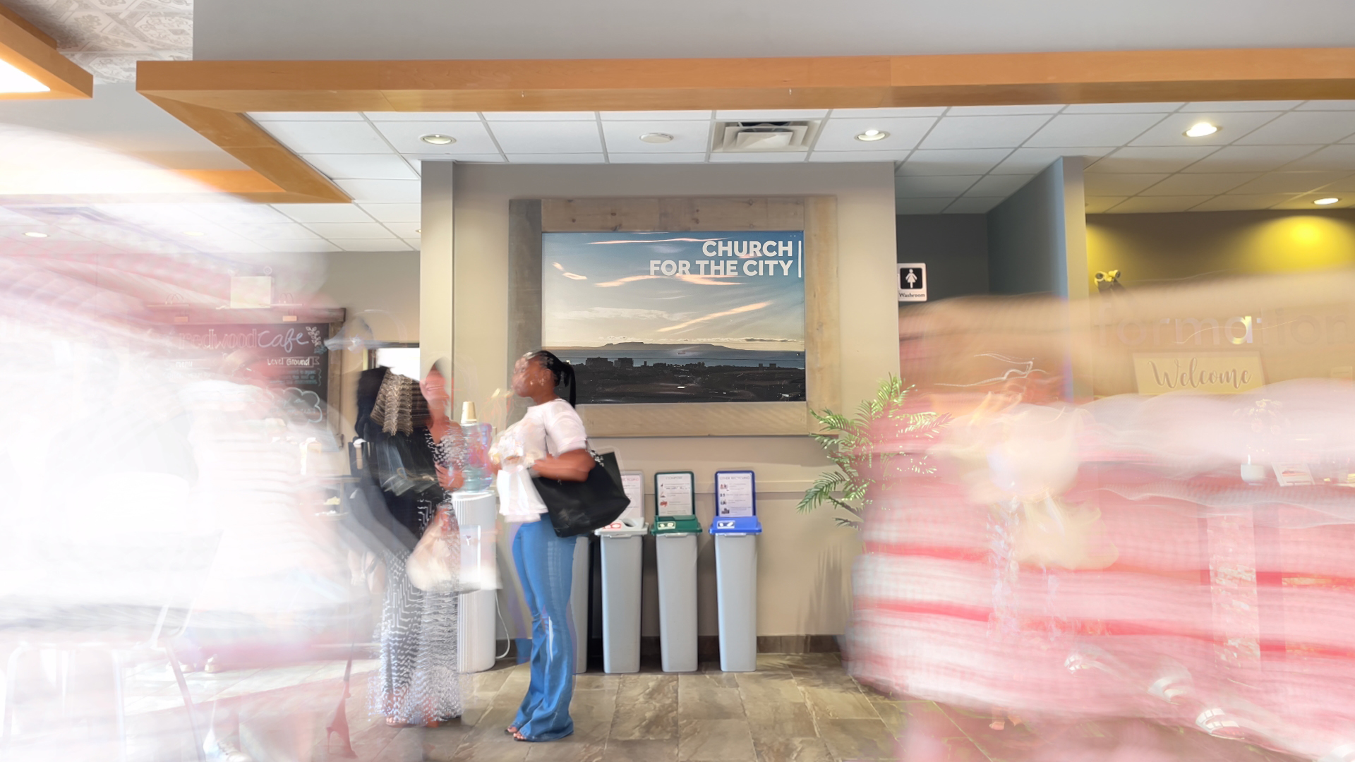 Redwood Park Church foyer with a large poster featuring the Sleeping Giant, a local landmark, with words superimposed on top: “Church for the City.”